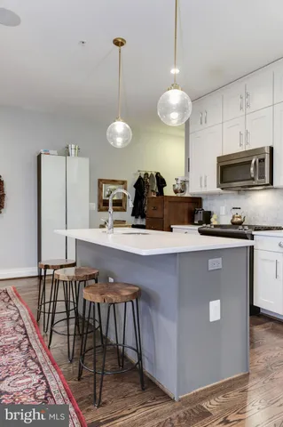 a kitchen with stainless steel appliances granite countertop white cabinets and a stove a oven with white countertops