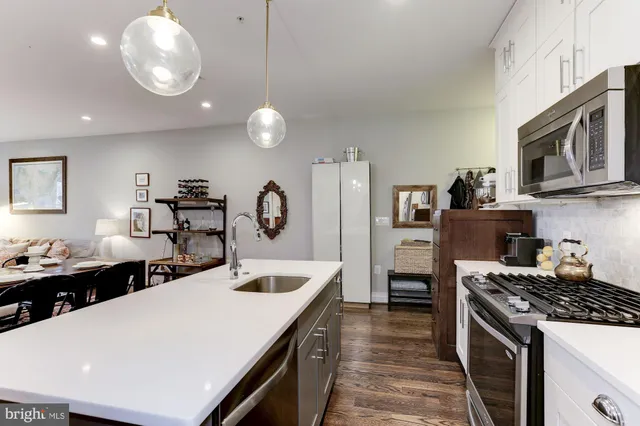a kitchen with stainless steel appliances kitchen island granite countertop a dining table and chairs