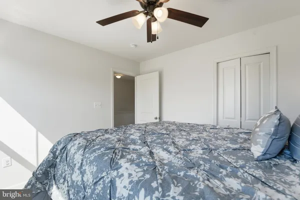 a bed room with a bed and a ceiling fan