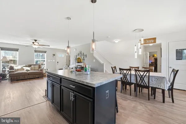 a kitchen with a table chairs and white cabinets