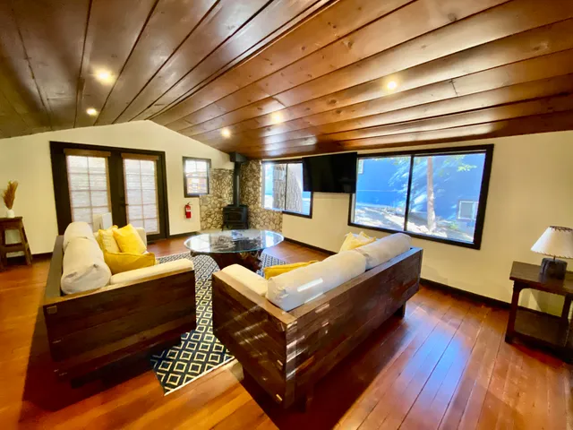 a living room with furniture a wooden floor and next to a window