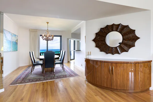 a view of a dining room with furniture a chandelier and wooden floor