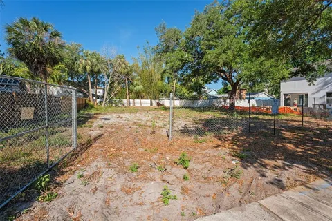 a view of a yard with plants and trees