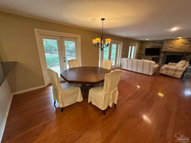 an open kitchen with wooden floor and refrigerator