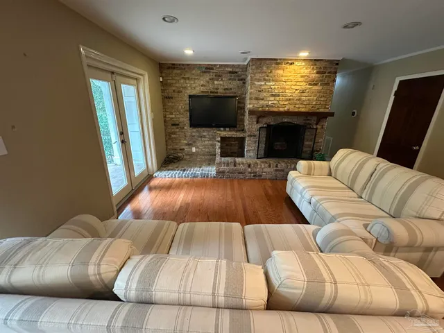 a dining room with furniture a chandelier and wooden floor