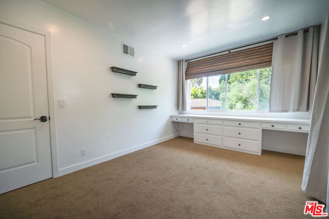 503 North Greencraig Road Los Angeles, CA 90049 - Photo 30 of 59 an empty room with a window and a ceiling fan