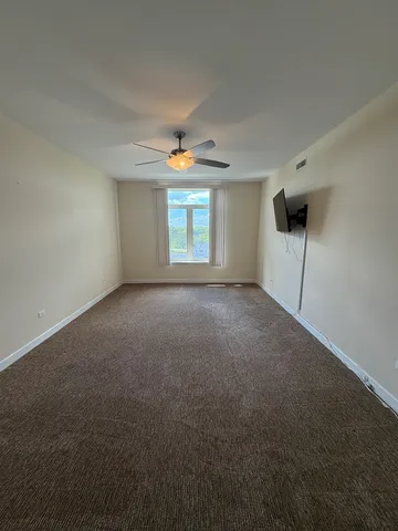 a view of a room with a ceiling fan and window