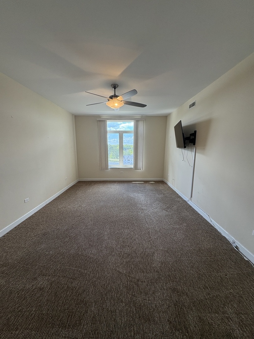 8300 Callie Avenue, Unit 610 Morton Grove, IL 60053 - Photo 17 of 32 a view of a room with a ceiling fan and window
