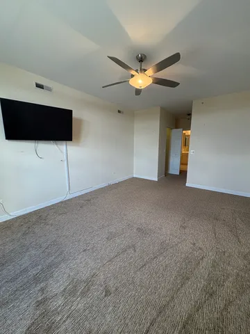 a view of an empty room with a ceiling fan