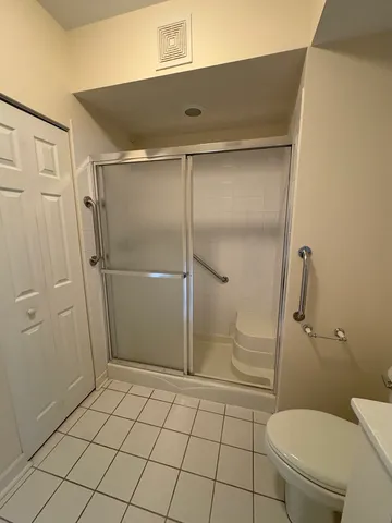 a bathroom with a granite countertop toilet and a shower