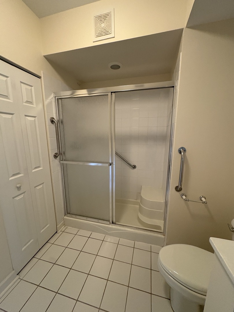 8300 Callie Avenue, Unit 610 Morton Grove, IL 60053 - Photo 21 of 32 a bathroom with a granite countertop toilet and a shower