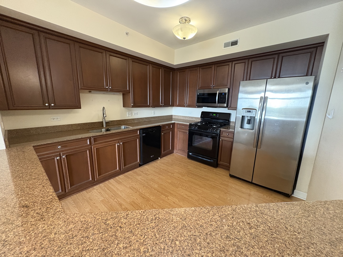 8300 Callie Avenue, Unit 610 Morton Grove, IL 60053 - Photo 5 of 32 a kitchen with stainless steel appliances granite countertop a refrigerator a sink a stove top oven and cabinets