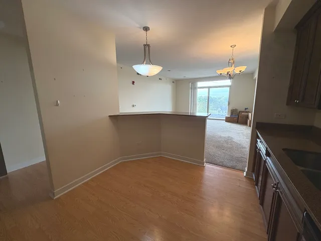 an empty room with wooden floor and chandelier