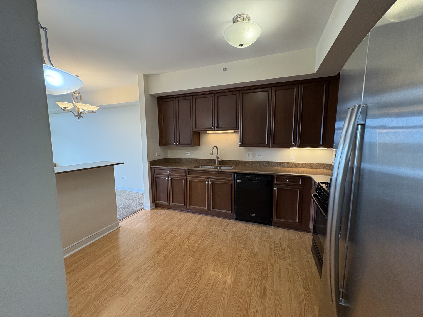 8300 Callie Avenue, Unit 610 Morton Grove, IL 60053 - Photo 9 of 32 a kitchen with stainless steel appliances granite countertop a stove a sink and a refrigerator