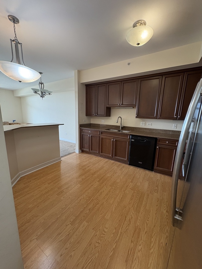 8300 Callie Avenue, Unit 610 Morton Grove, IL 60053 - Photo 10 of 32 a kitchen with kitchen island a stove a sink and a refrigerator