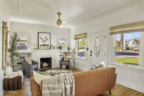a living room with furniture a fireplace and a chandelier