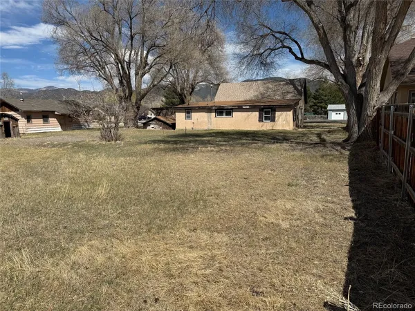 a front view of a house with large trees