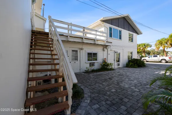 a view of a big house with wooden fence