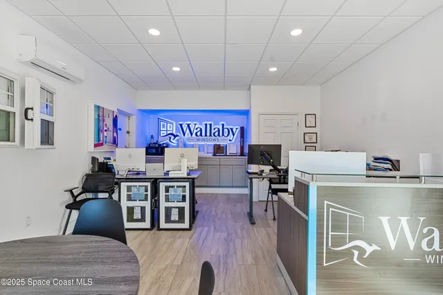 a living room with stainless steel appliances furniture and a kitchen view