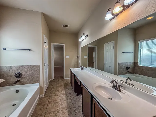 a view of a big room with a ceiling fan and a kitchen