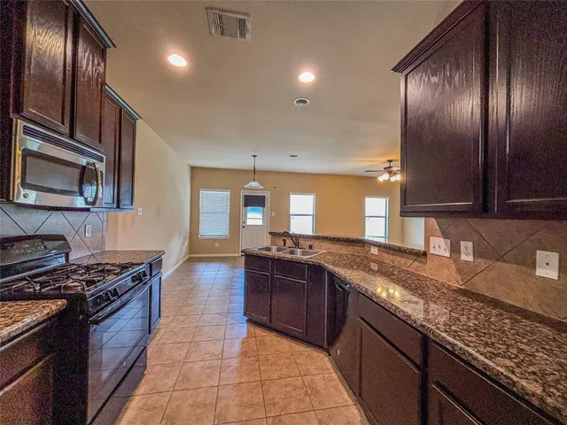 a kitchen with stainless steel appliances granite countertop a stove and a sink