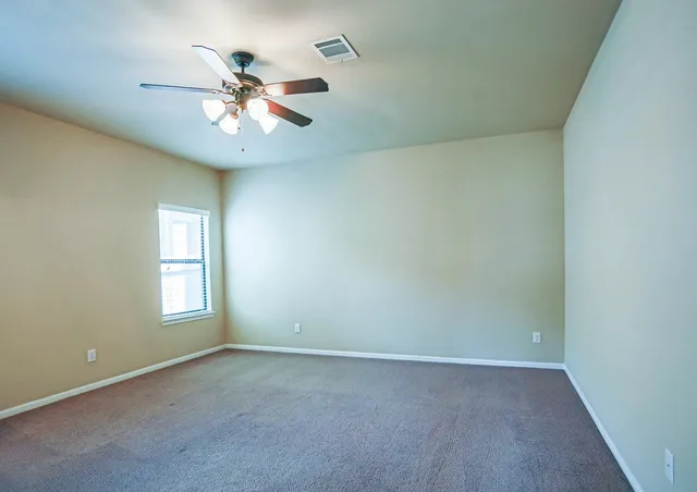an empty room with closet and windows