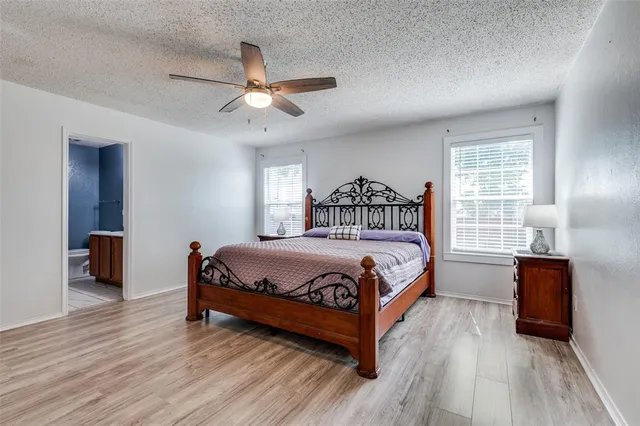 a bedroom with a large bed and a ceiling fan