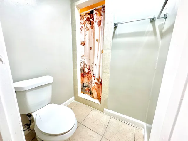 a white toilet sitting next to a shower curtain