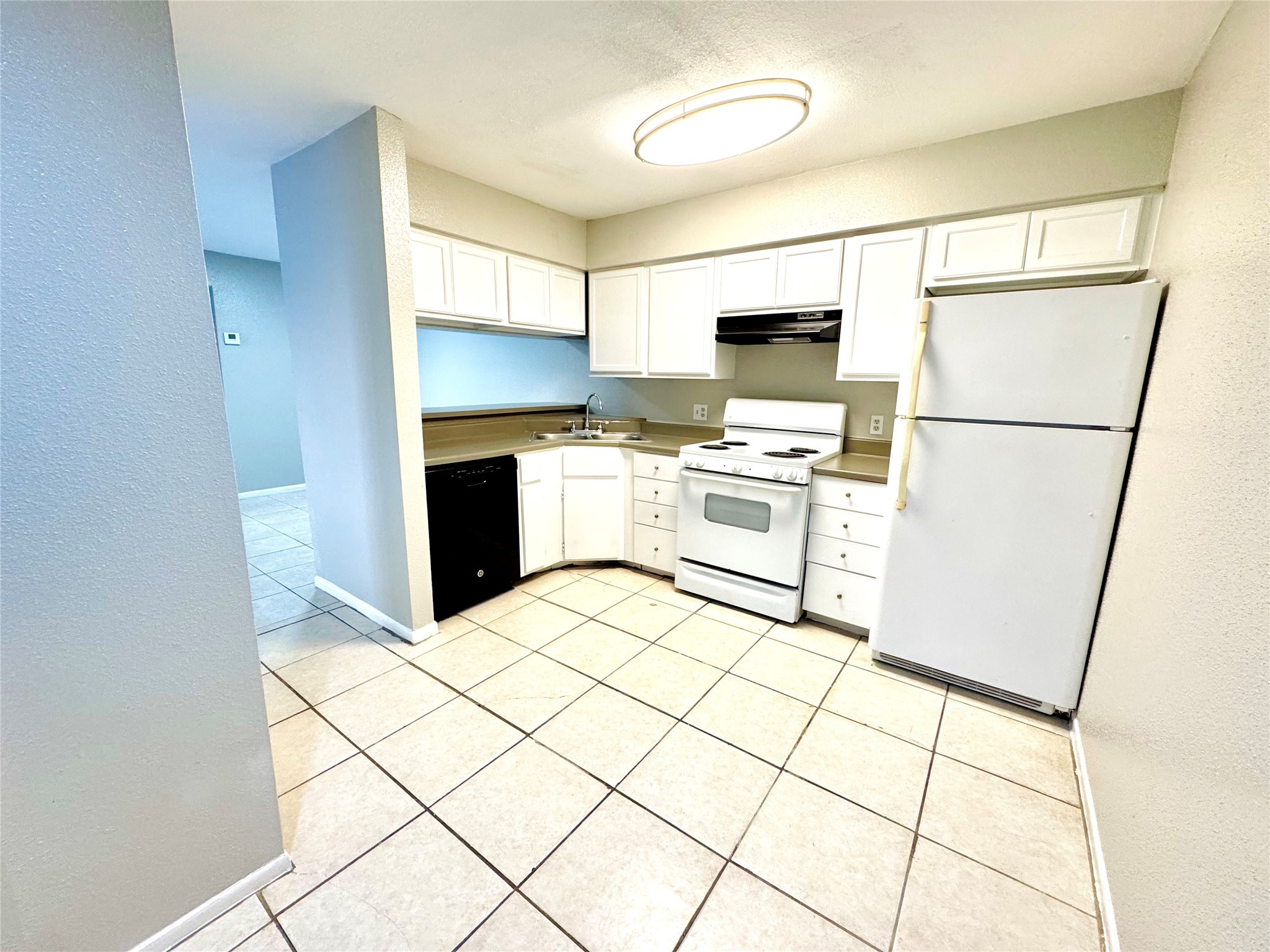 9090 South Braeswood Boulevard, Unit 47 Houston, TX 77074 - Photo 4 of 30 a kitchen with stainless steel appliances a stove a sink and white cabinets