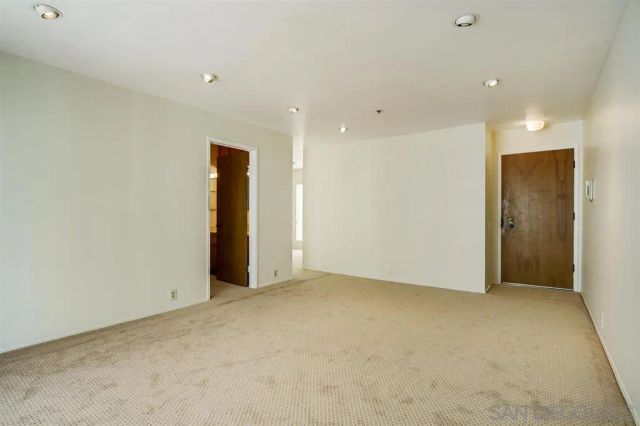 an empty room with closet and a hallway