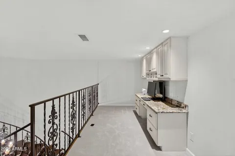 a view of a hallway with wooden floor and a living room