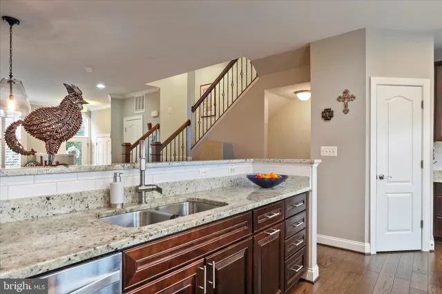a kitchen with granite countertop a stove top oven cabinetry a sink and dishwasher