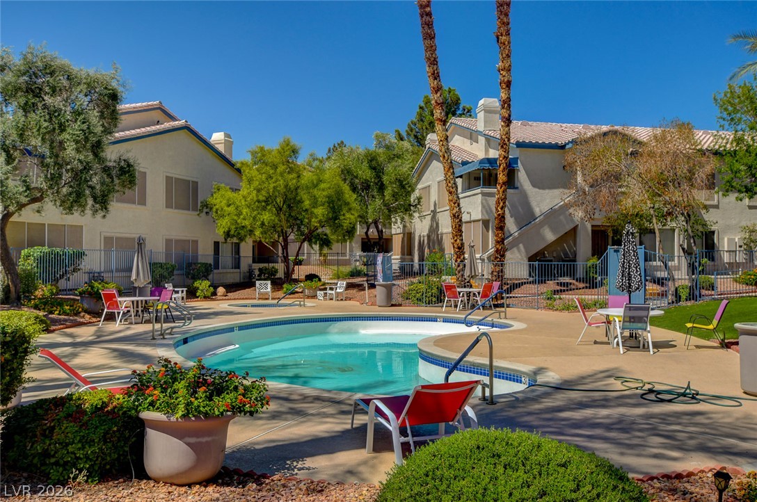 3425 East Russell Road, Unit 223 Las Vegas, NV 89120 - Photo 42 of 47 A refreshing pool awaits, surrounded by lush landscaping and inviting outdoor seating.