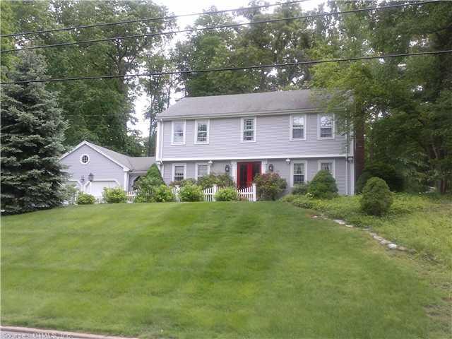 a front view of a house with a yard and trees