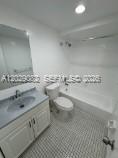 8445 Springtree Drive, Unit 409A Sunrise, FL 33351 - Photo 9 of 9 a bathroom with a sink a toilet and a mirror