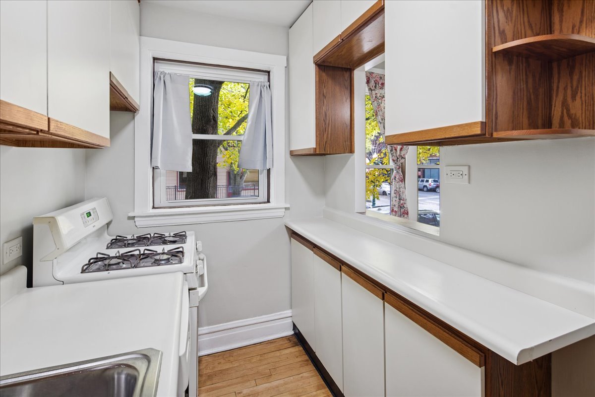 734 West Wrightwood Avenue, Unit B Chicago, IL 60614 - Photo 7 of 21 a kitchen with stainless steel appliances a stove a sink and a microwave