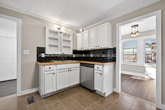a kitchen with granite countertop a stove a sink and a refrigerator