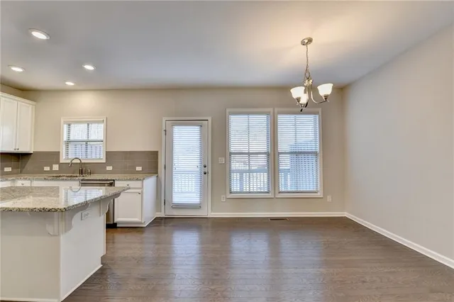 a view of a kitchen with kitchen island white cabinets and wooden floor