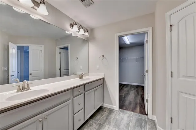 a spacious bathroom with a granite countertop sink a toilet and a mirror