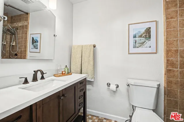 a bathroom with a sink mirror vanity and toilet