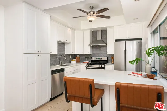 a kitchen with stainless steel appliances a stove a sink island and a refrigerator