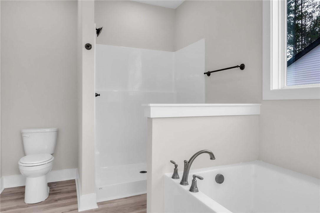 121 Ashley Drive Pelzer, SC 29669 - Photo 13 of 25 Bathroom featuring a bath, wood finished floors, and a walk in shower
