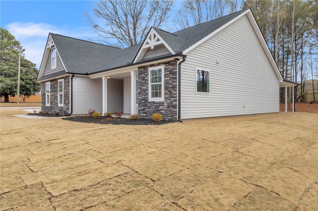 121 Ashley Drive Pelzer, SC 29669 - Photo 3 of 25 View of side of home featuring stone siding and a shingled roof
