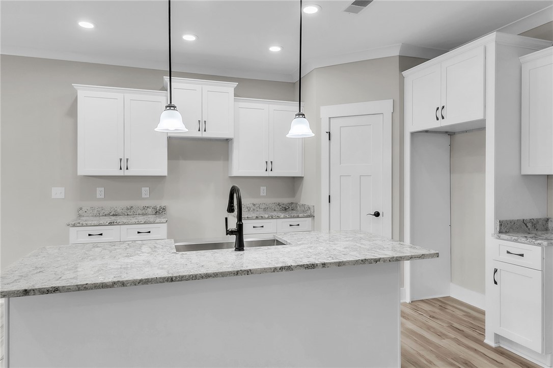 121 Ashley Drive Pelzer, SC 29669 - Photo 7 of 25 Kitchen featuring light stone counters, an island with sink, hanging light fixtures, white cabinets, and recessed lighting