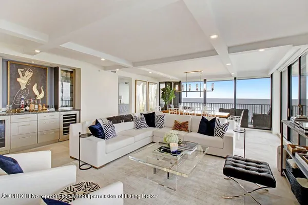 a living room with furniture kitchen view and a large window