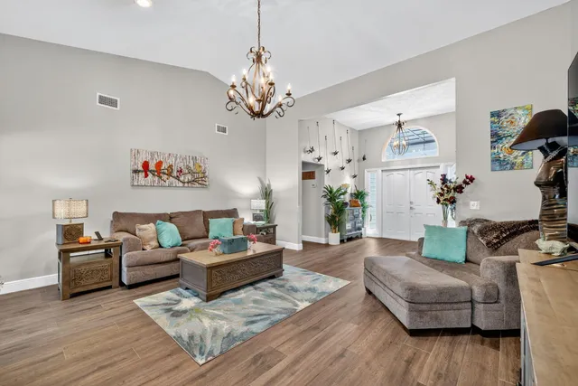 a living room with furniture and a chandelier