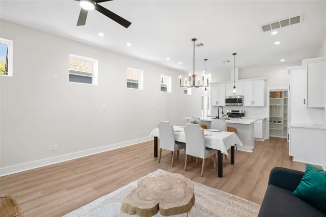 a dining room with furniture and kitchen view