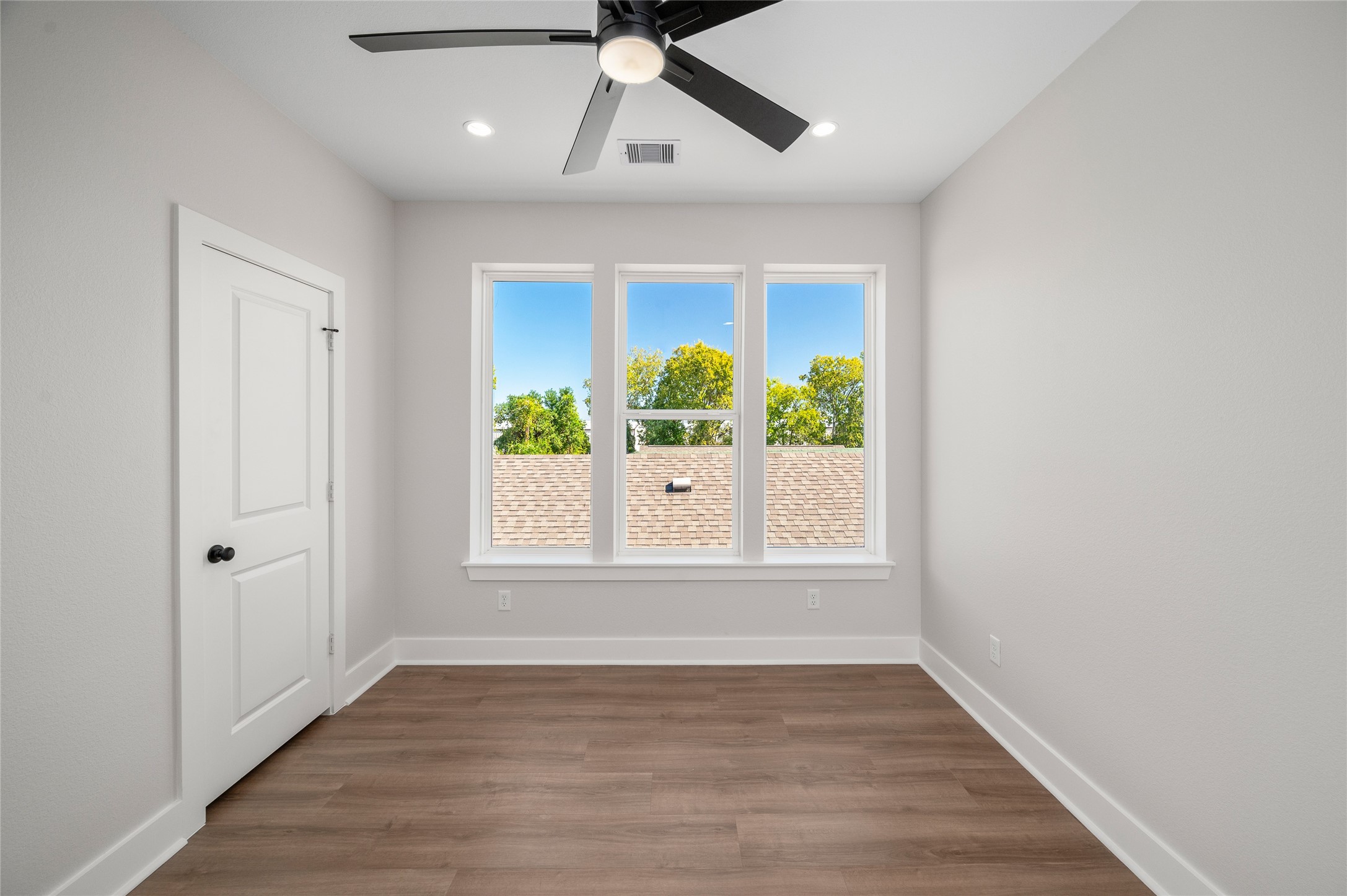 921 East 38th Street Houston, TX 77022 - Photo 35 of 40 an empty room with wooden floor chandelier and window