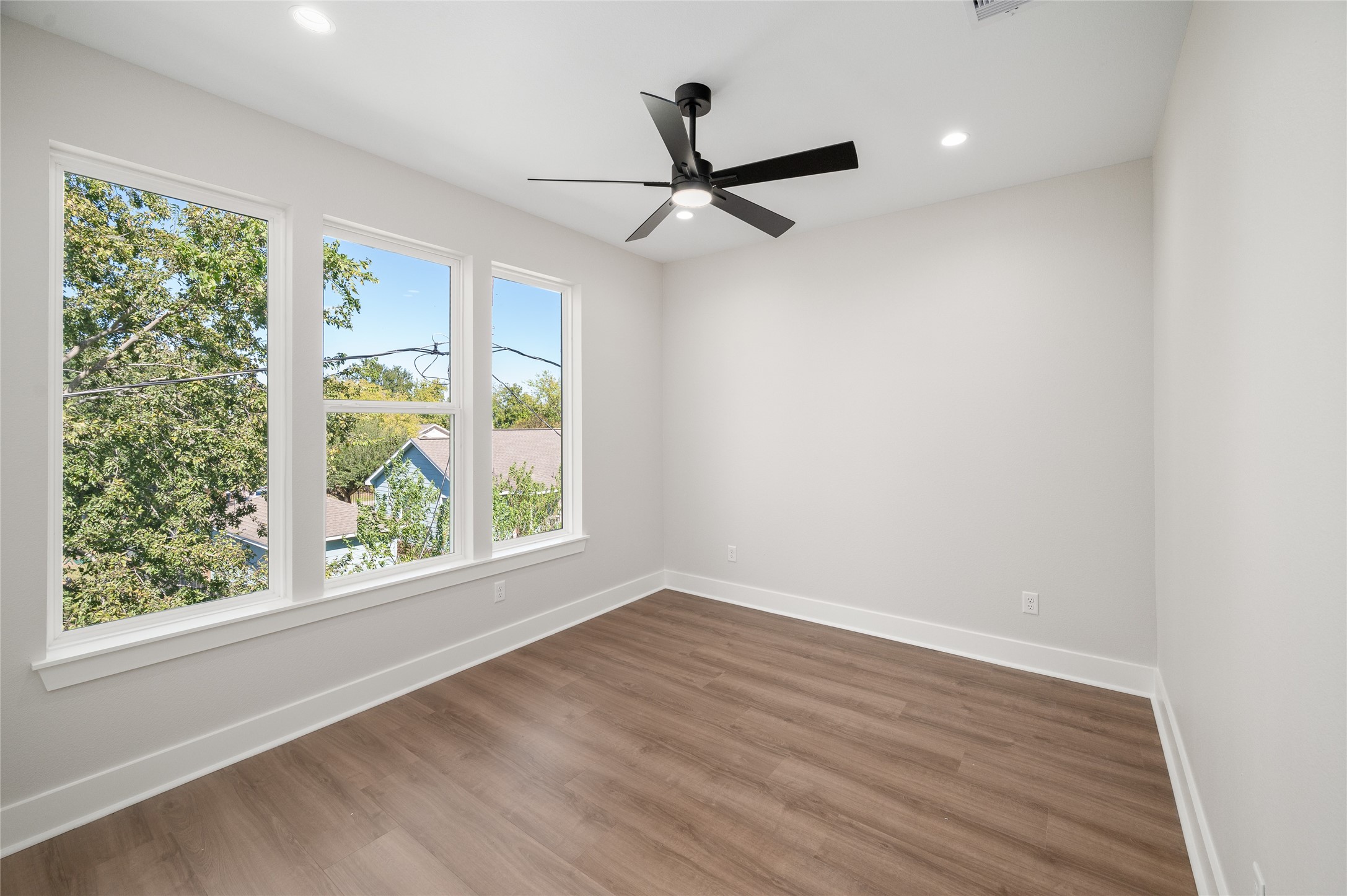 921 East 38th Street Houston, TX 77022 - Photo 37 of 40 an empty room with wooden floor fan and windows