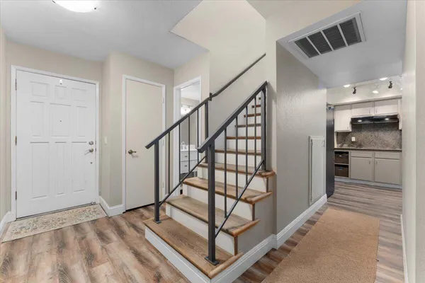 a view of a hallway with wooden floor and staircase